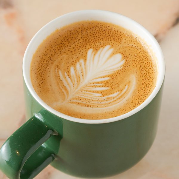 Latte art in a green coffee cup at a Coffee Cafe in Toronto.