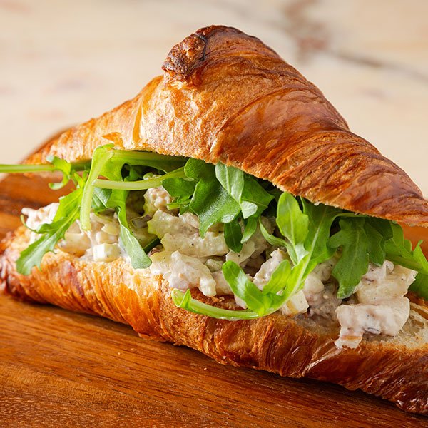 Fresh croissant sandwich served as a lunch option at a Toronto coffee shop with patio seating.