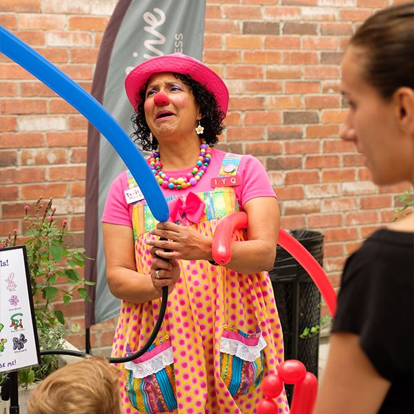 Entertainer blowing balloons for children during a family-friendly event at The Rosemount Cafe.
