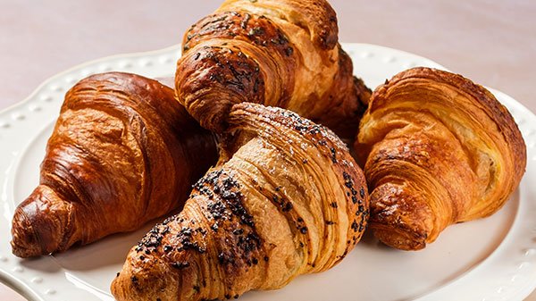 Platter of butter, almond, chocolate hazelnut, pistachio, and crema croissants for dessert catering in Toronto.
